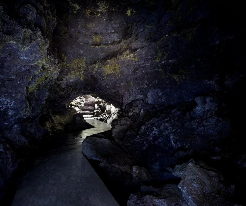 Exploring the depths of Torres Cave on Pico Island, Azores. The image showcases the intriguing underground landscape with intricate rock formations illuminated by soft lighting. Stalactites and stalagmites create a captivating environment, offering a glimpse into the hidden wonders of the island's unique subterranean world.