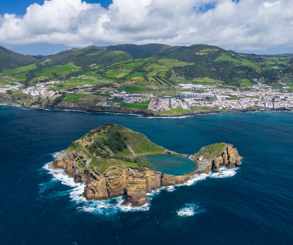 Scenic view of Vila Franca Islet, Azores. The image captures the volcanic islet's horseshoe-shaped crater, which encircles a calm and inviting turquoise lagoon. Surrounded by the deep blue ocean, the islet stands as a natural sanctuary for marine life, offering a picturesque and tranquil escape.