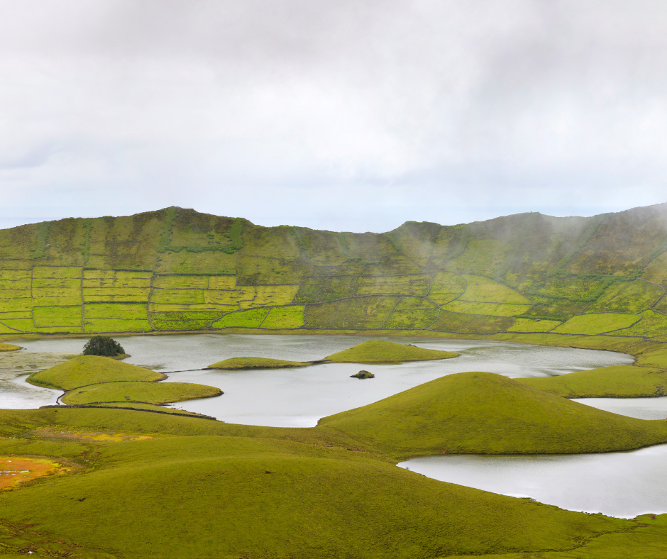 Mesmerizing view of Caldeirão, Azores. The image showcases a lush and verdant caldera, or volcanic crater, enveloped by dense vegetation. Misty clouds drift above the vibrant landscape, highlighting the natural beauty of this secluded and serene location.