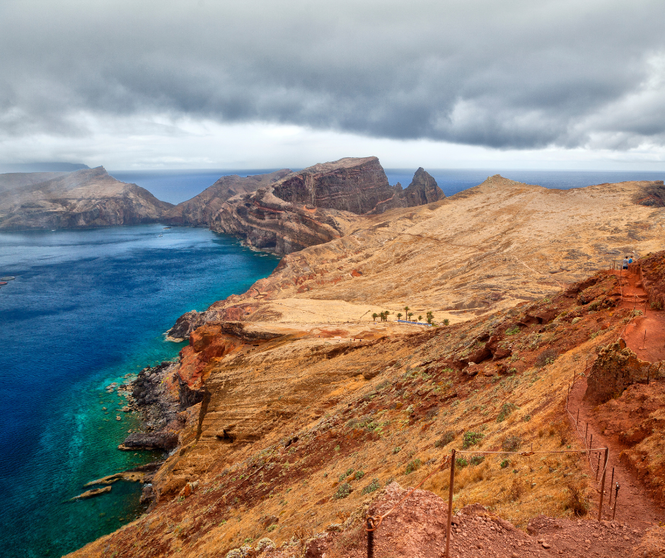 Dynamic coastal landscape of Ponta de São Lourenço, Madeira Island. The photo captures the rugged beauty of the peninsula, where steep cliffs meet the deep blue Atlantic Ocean. Natural rock formations and sparse vegetation paint a scene of raw and captivating nature along the island's easternmost poin