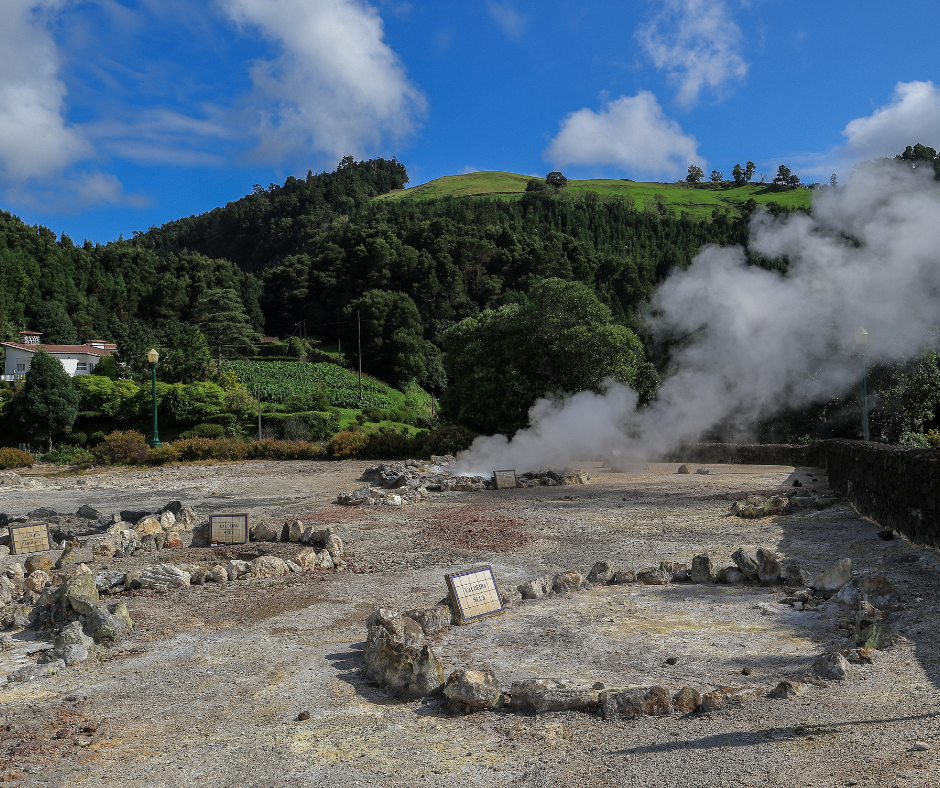 Captivating geothermal landscape of Furnas in the Azores. The image showcases bubbling hot springs, steaming fumaroles, and lush vegetation in this volcanic region. The natural beauty is framed by rolling hills and serene waters, offering a glimpse into the unique geological wonders that define the Furnas area