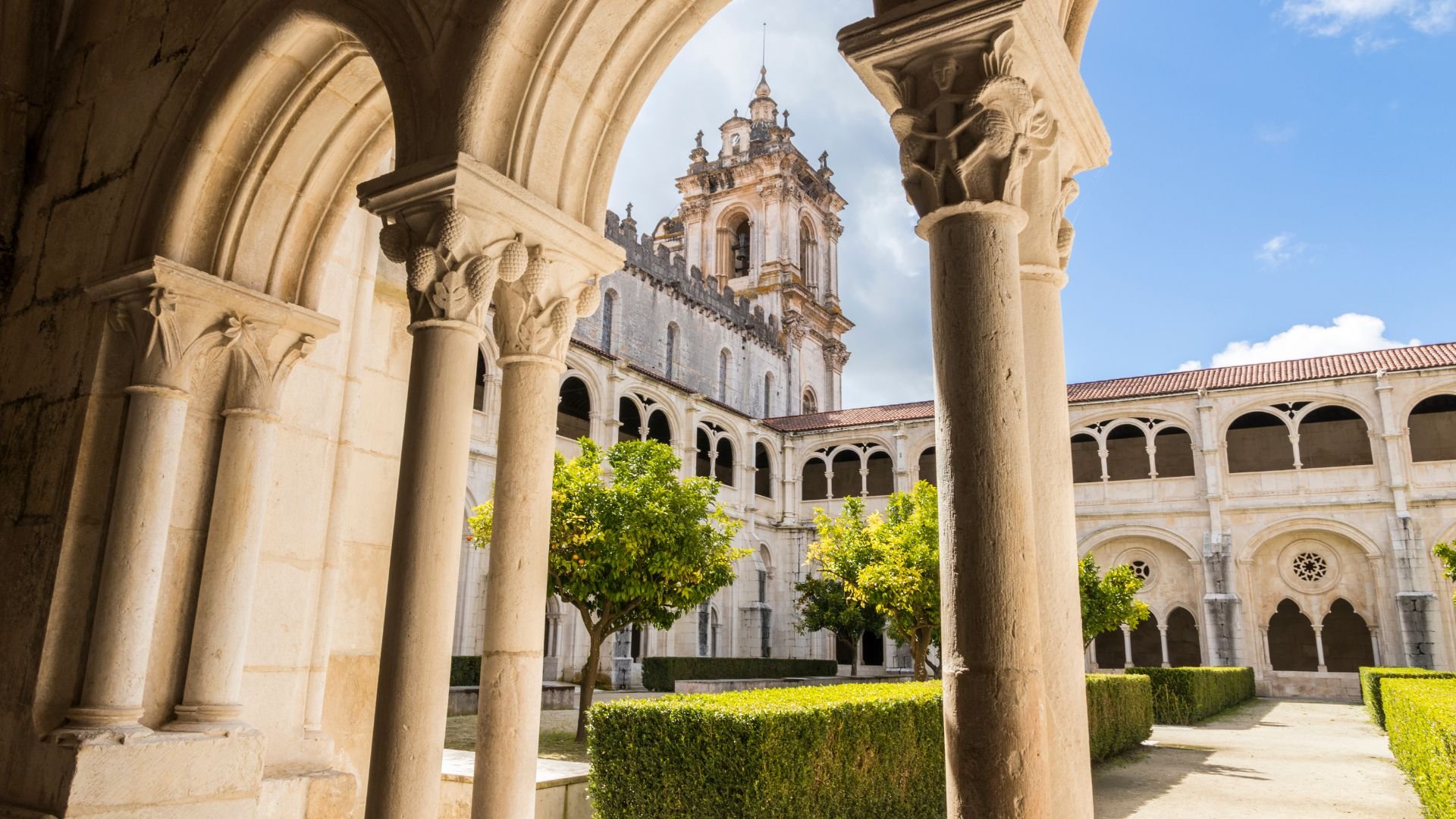 Exterior view of Alcobaça Monastery, Portugal, showcasing its impressive Gothic architecture and serene surroundings.