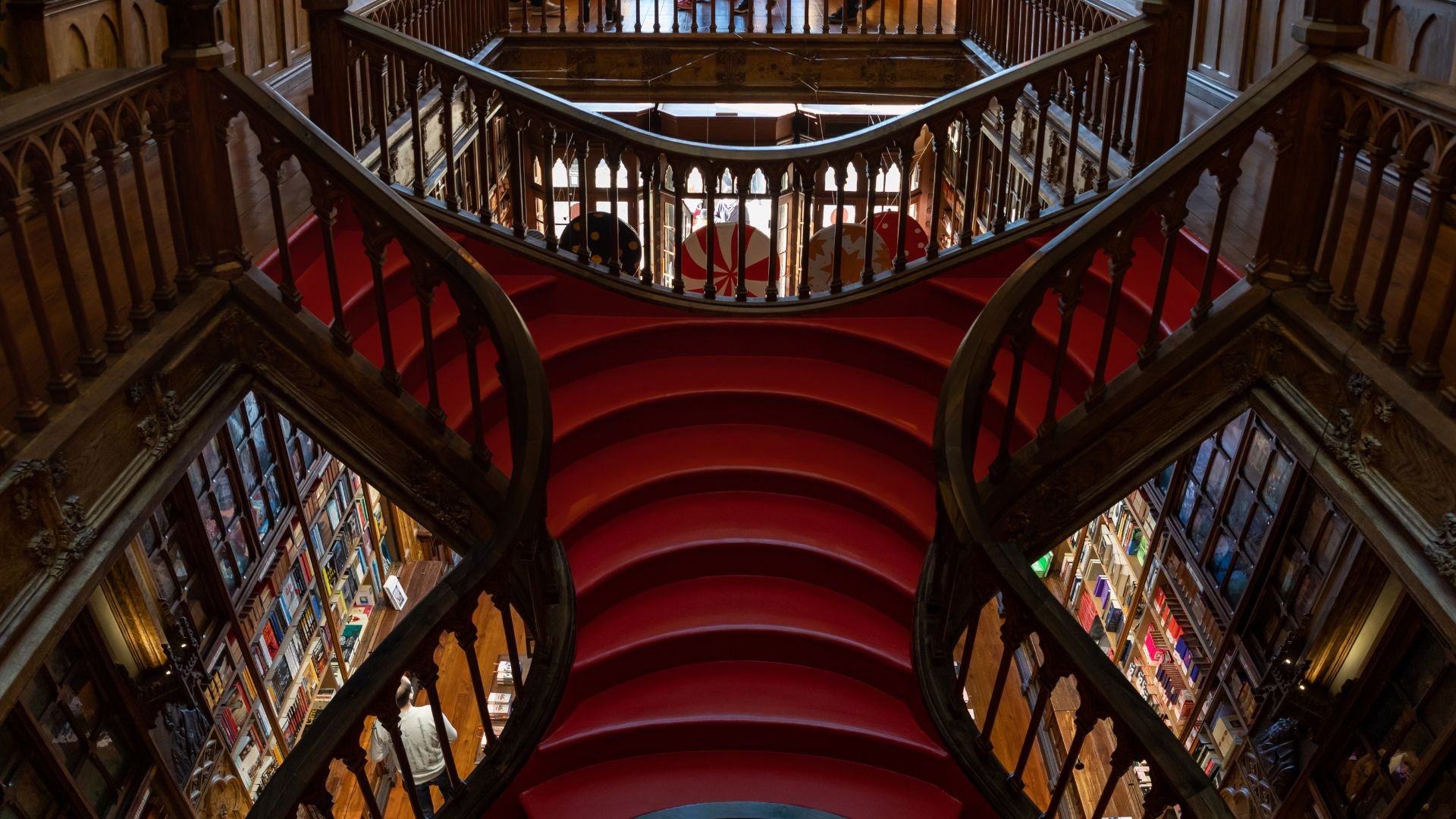 Interior of Livraria Lello, a historic bookstore in Porto, Portugal, known for its stunning Neo-Gothic architecture, intricate wooden staircases, and ornate bookshelves